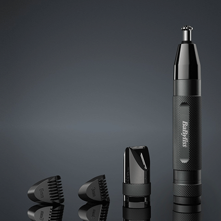 Recortador de vello de nariz y orejas BaByliss negro con accesorios. Colocado sobre una superficie gris oscuro.