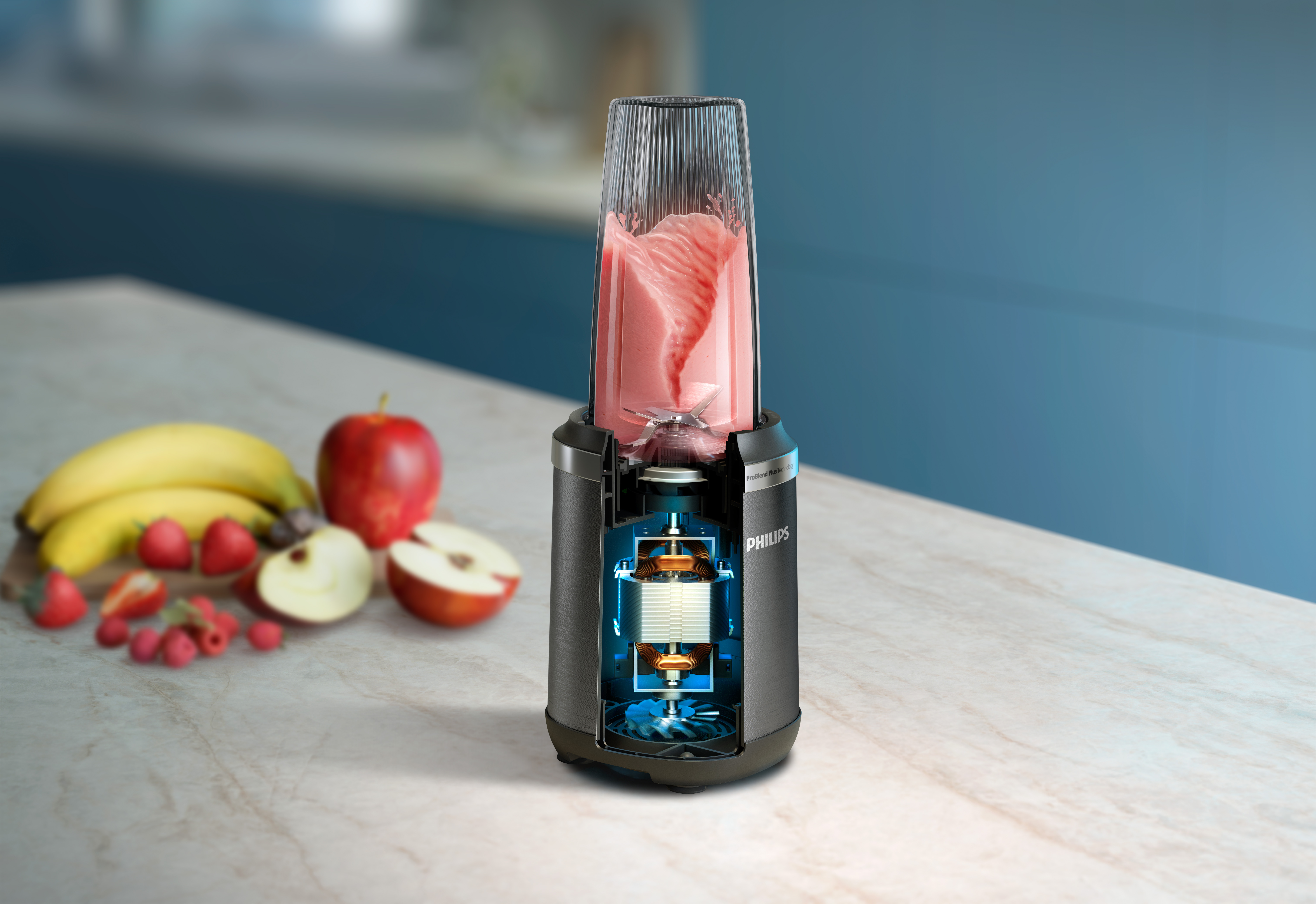 Licuadora con batido rosa. Frutas y el motor de la licuadora son visibles.