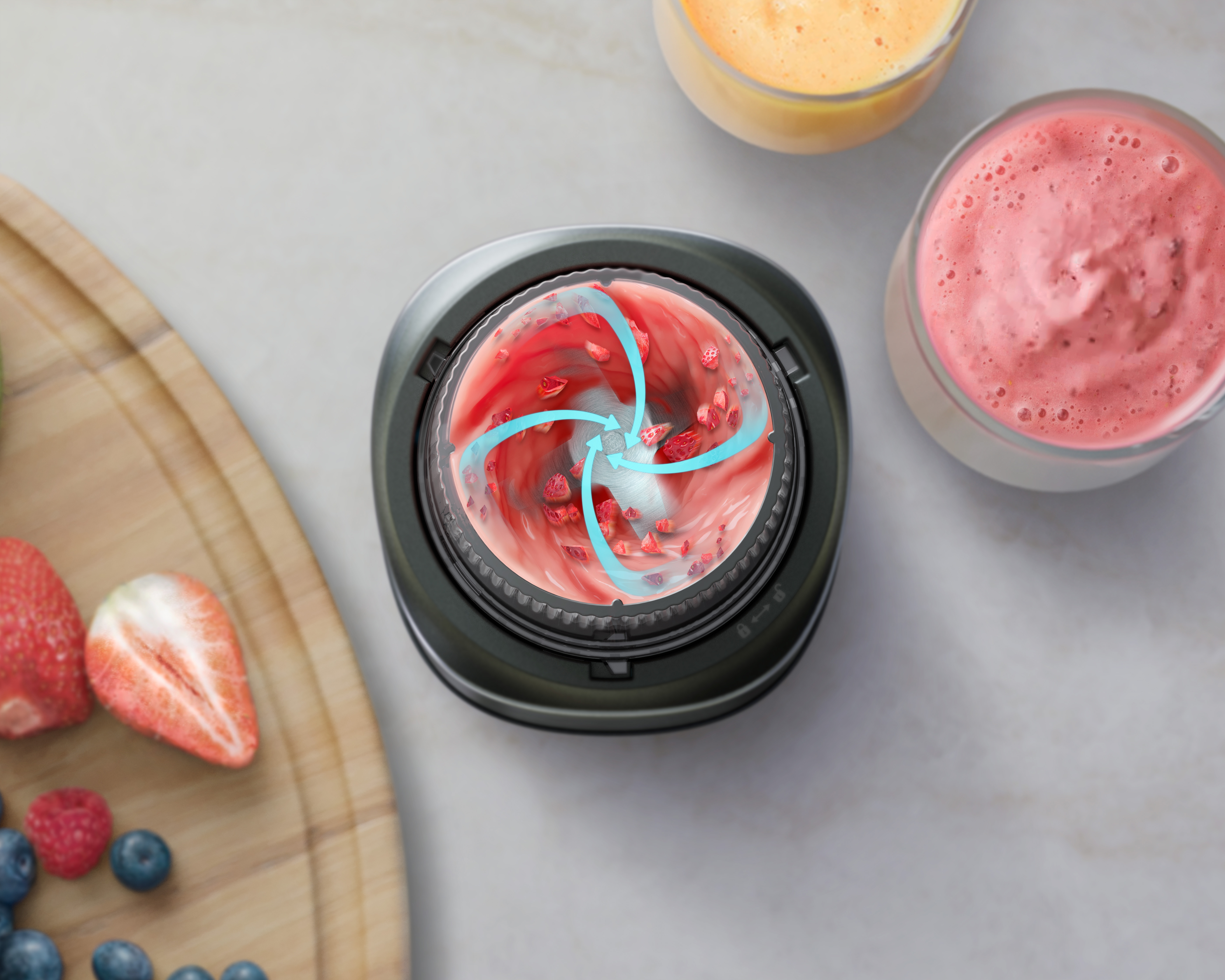 Un recipiente de licuadora con fresas siendo mezcladas. Flechas azules indican la dirección de mezcla.