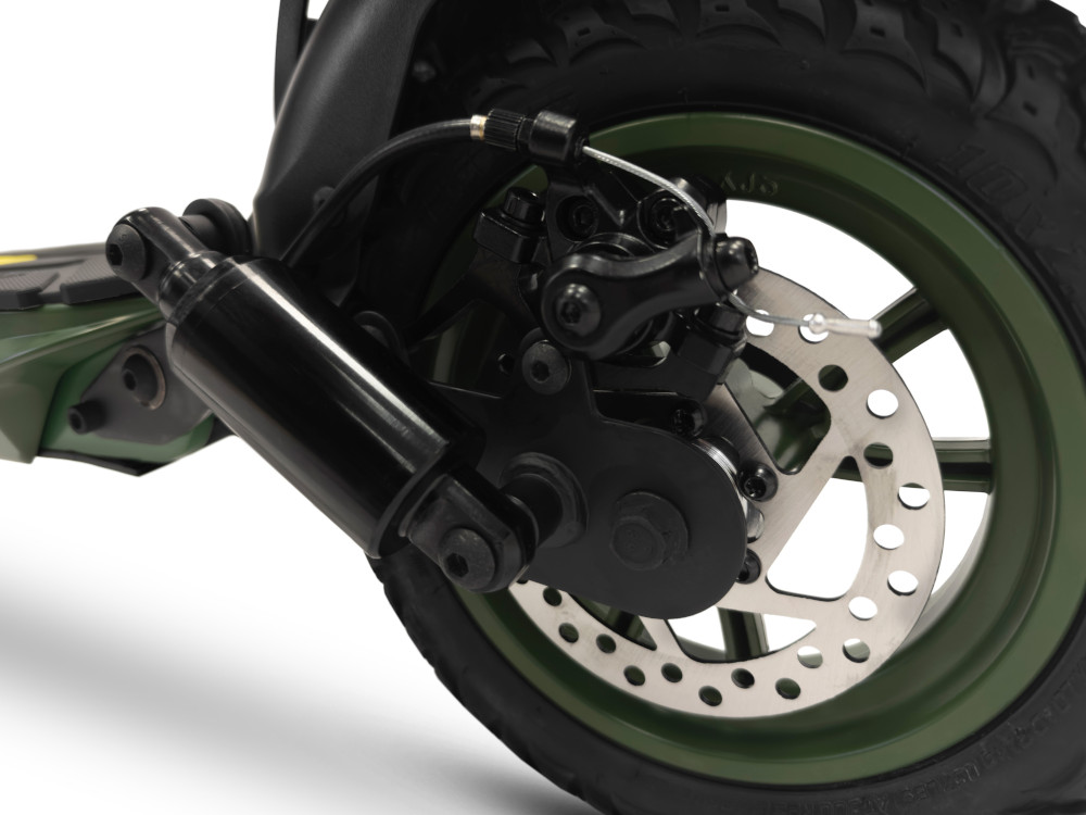 Close-up van de zwarte schokdemper, schijfrem en groene wiel van een elektrische scooter.