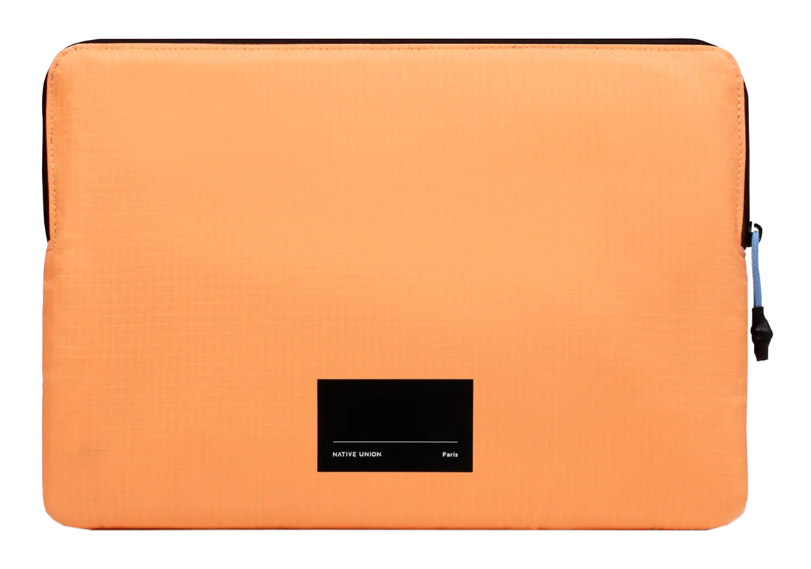 Orangene Laptoptasche mit schwarzem Etikett. Die Tasche ist schlicht und hat einen schwarzen Reißverschluss und einen kleinen blauen Zipper.