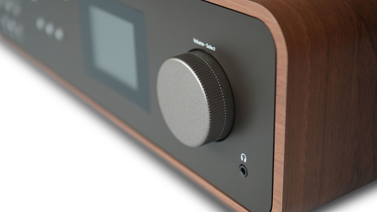Una vista ravvicinata di un ricevitore audio marrone con una manopola del volume e uno schermo.