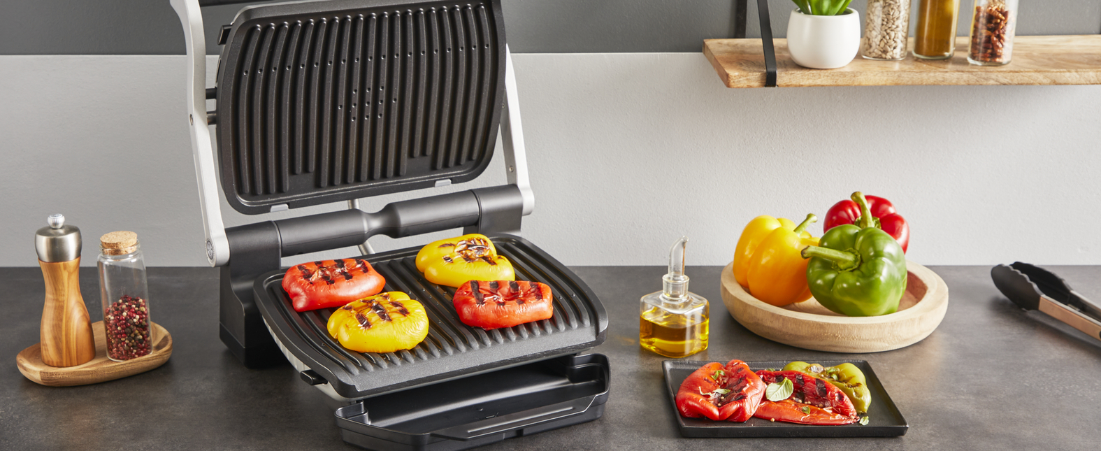 Grill sült paprikával. Más paprikák fa tányéron és tálcán, olajjal és fűszerekkel.