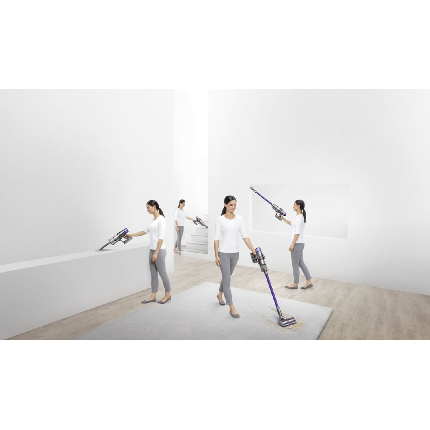 Plusieurs femmes utilisant des aspirateurs Dyson dans une pièce blanche avec un tapis gris clair.