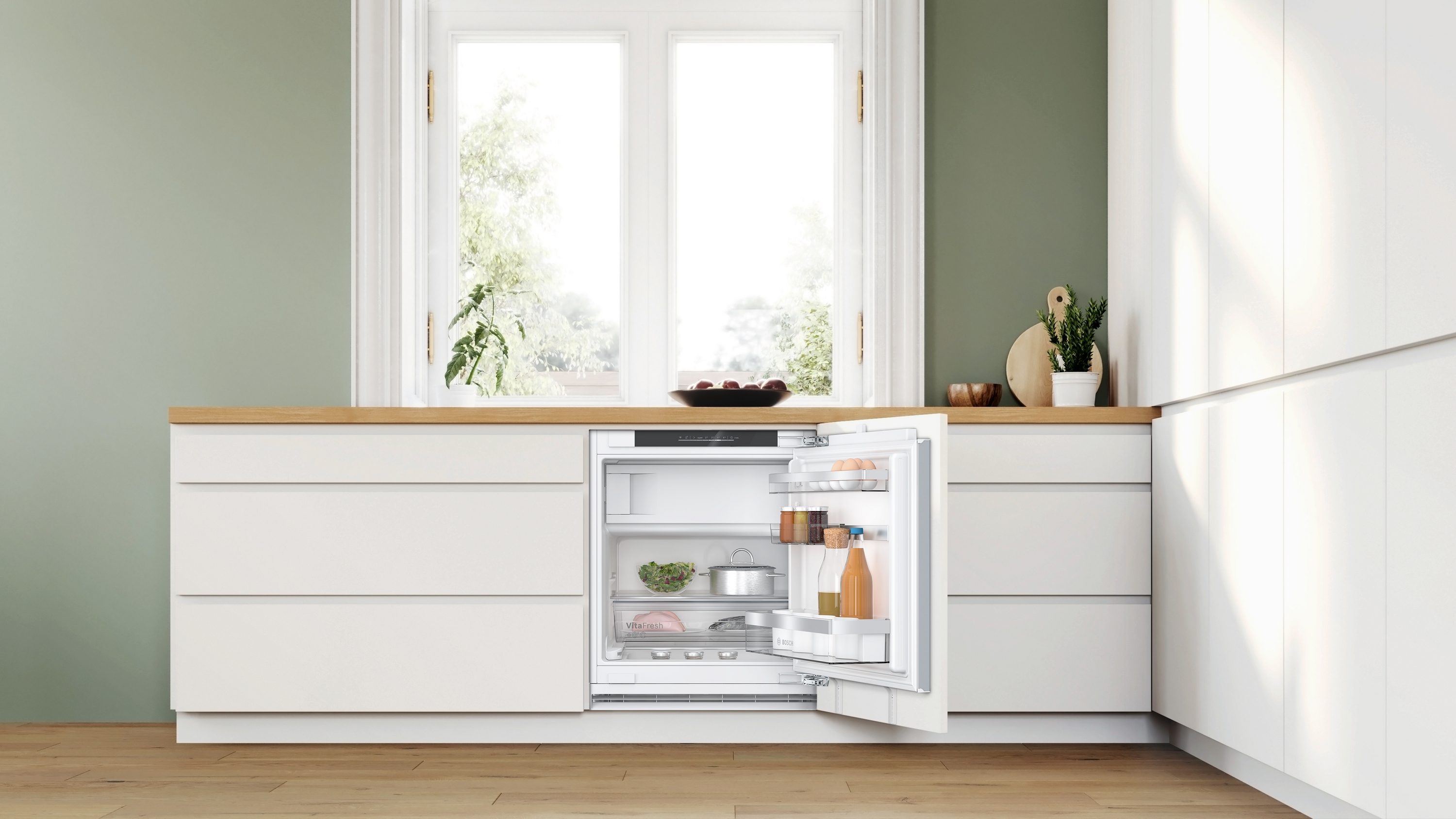 Küche mit eingebautem weißen Kühlschrank, Tür offen, mit Essen darin.