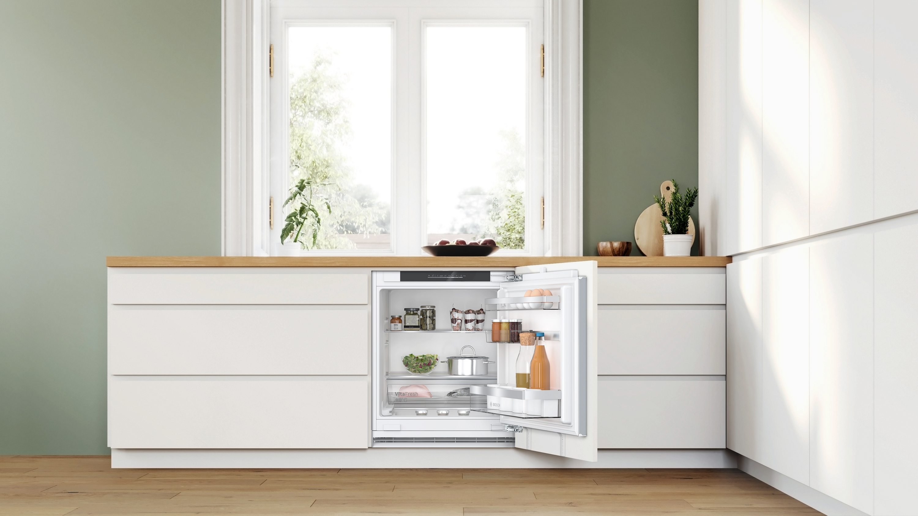 Küche mit offenem Kühlschrank. Lebensmittel sind sichtbar. Fenster im Hintergrund.
