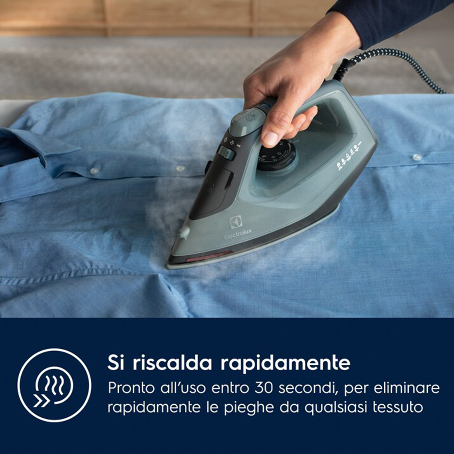 Stiratura di una camicia blu con vapore. Il testo dice: Si riscalda subito.
