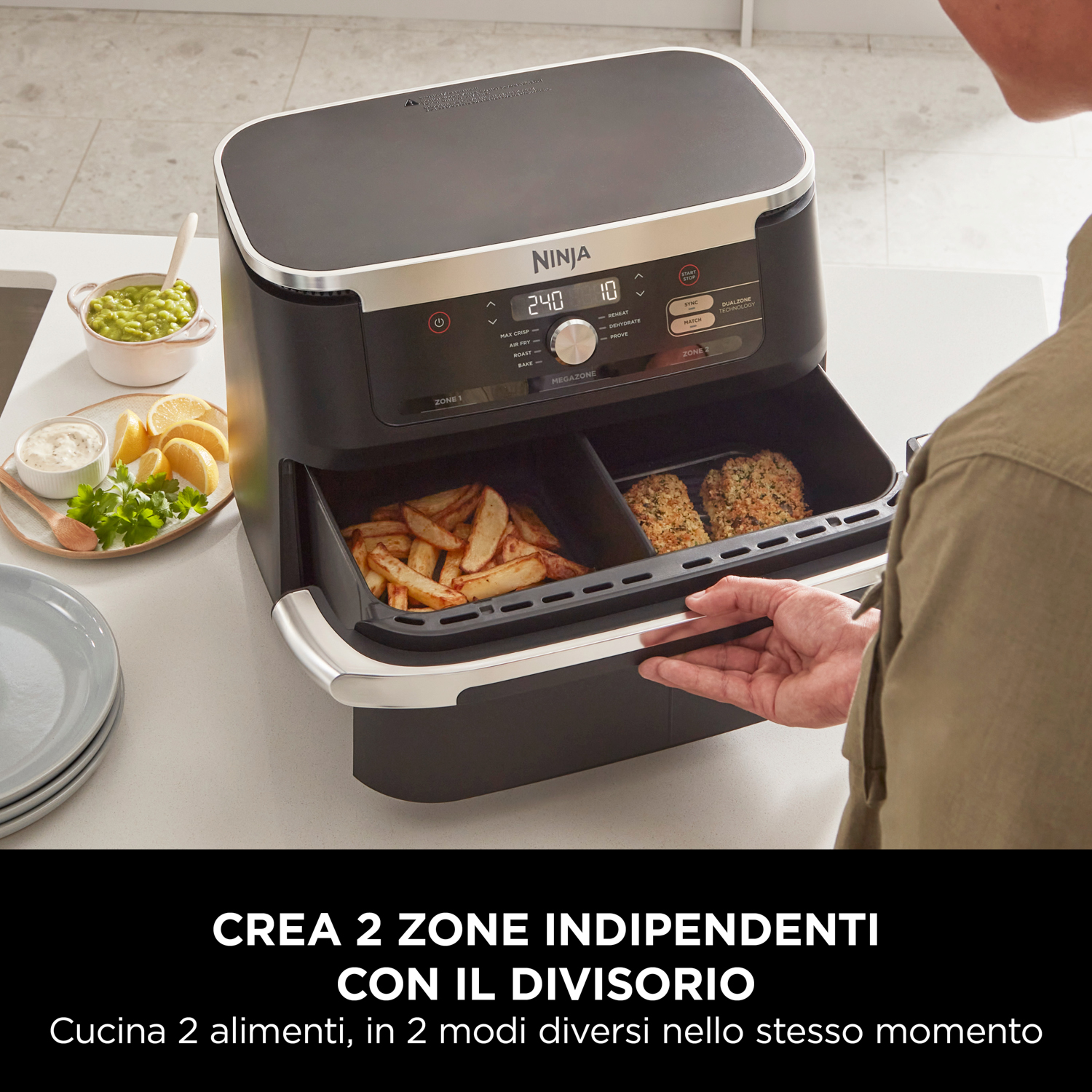Friggitrice ad aria Ninja con due scomparti e le mani di una persona.
