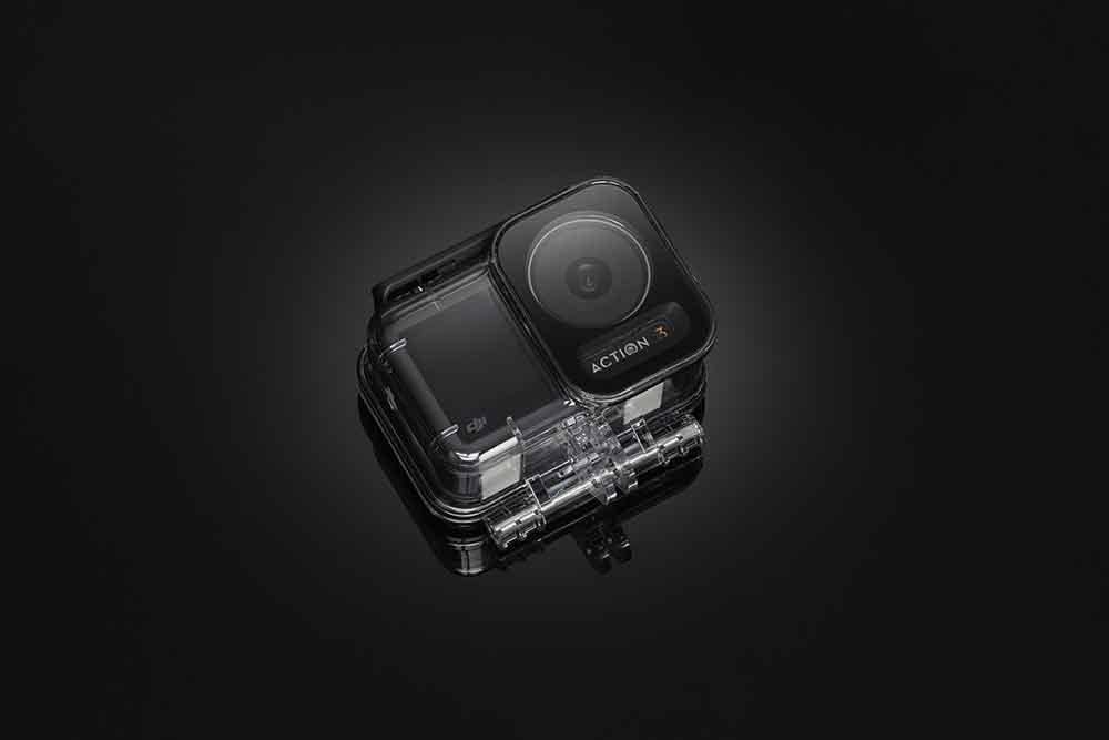 Action camera in een transparante behuizing, op een donker oppervlak, zwarte achtergrond.