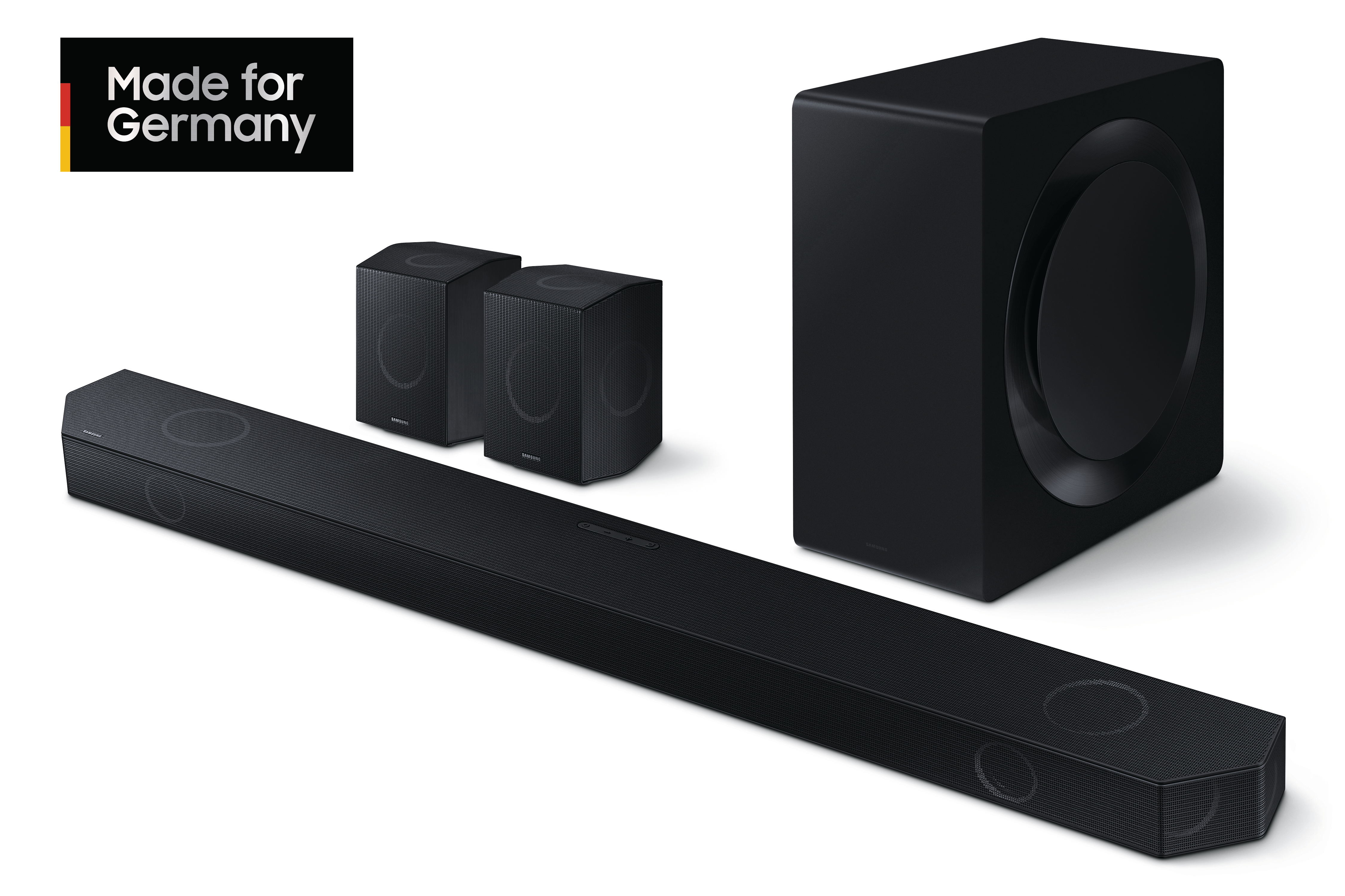 Eine schwarze Soundbar, zwei Lautsprecher und ein Subwoofer vor weißem Hintergrund. Made for Germany.