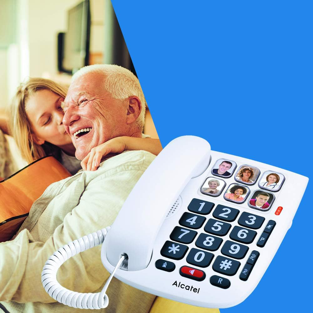 Idős férfi és nő mosolyognak, fehér telefonnal, nagy gombokkal.