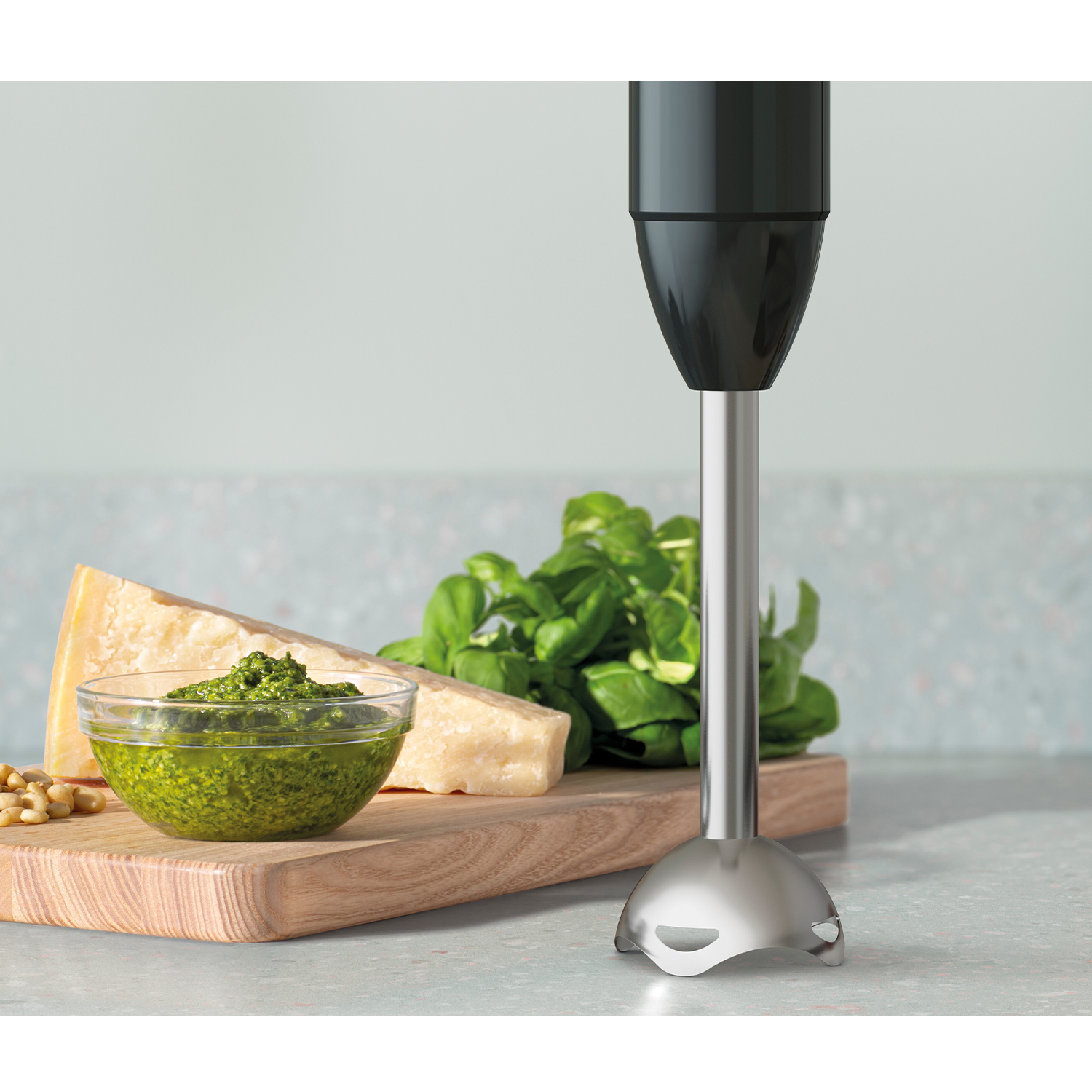 Frullatore a immersione con pesto, formaggio e basilico.
