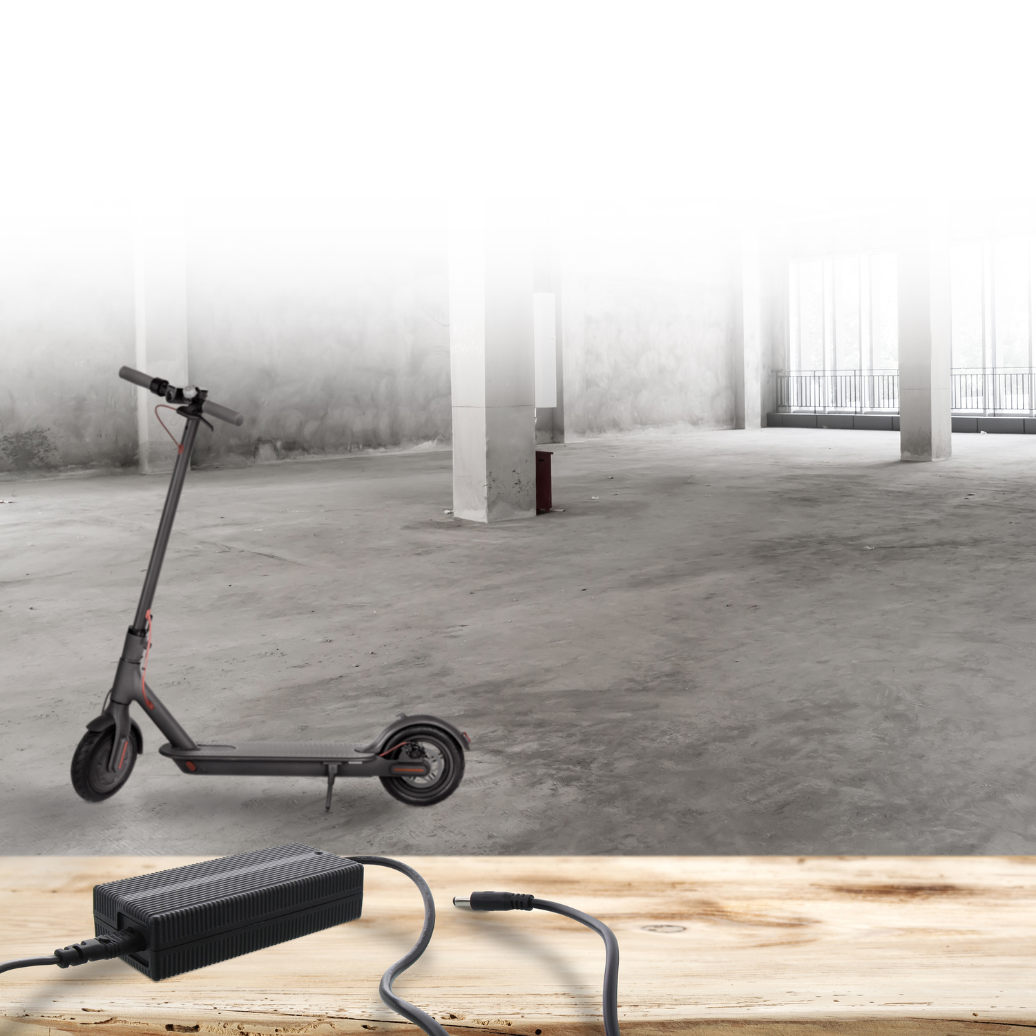 Zwarte scooter en oplader op een houten oppervlak.