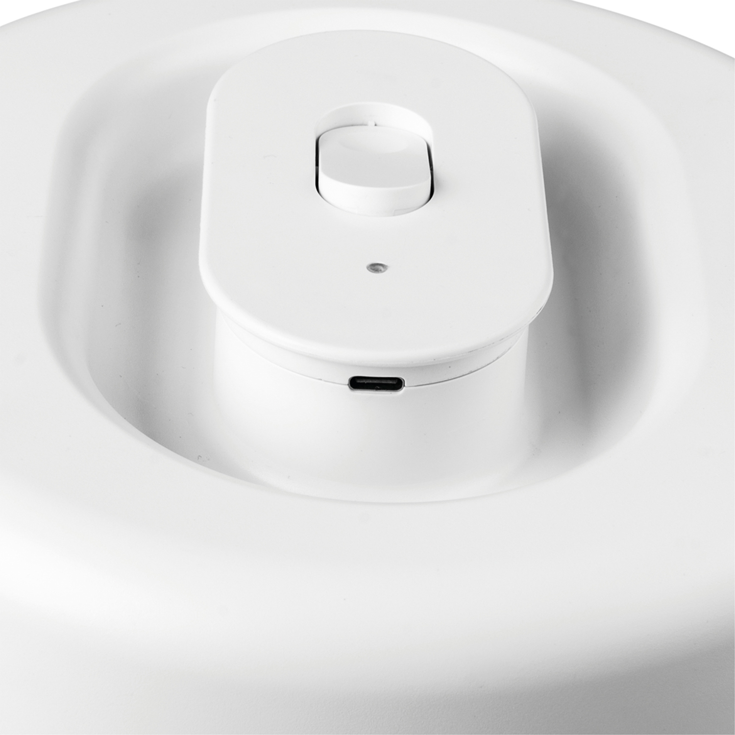 Dispositivo bianco con un pulsante e una porta USB. È su uno sfondo bianco.