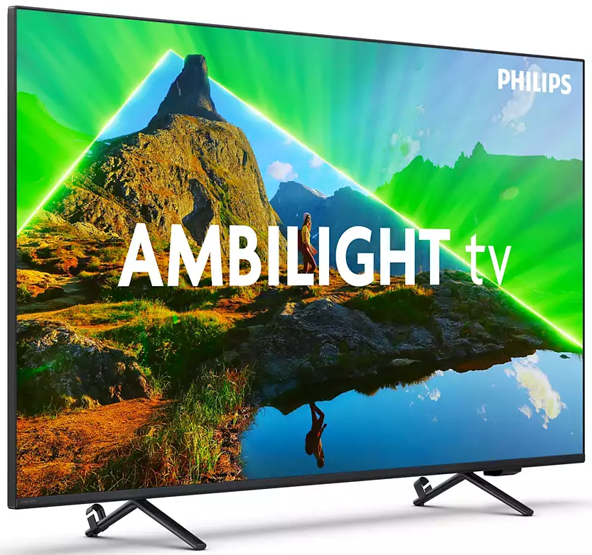 Telewizor Philips Ambilight wyświetla krajobraz górski z osobą. Zielone i niebieskie światło na ekranie, czarny stojak.