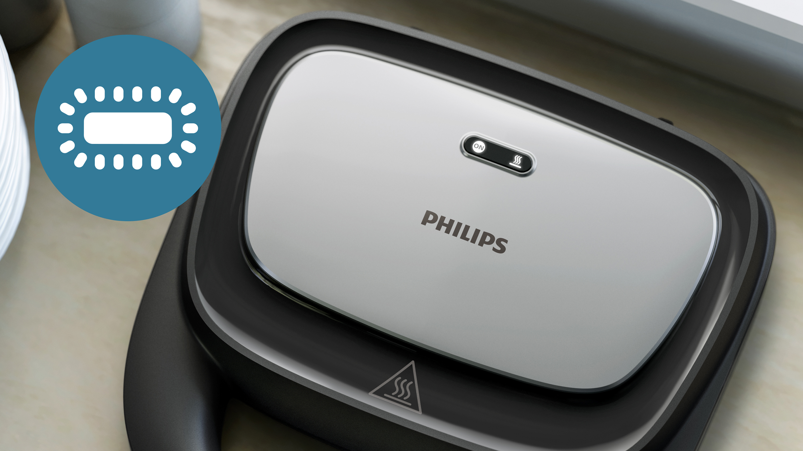 Primer plano de una sandwichera Philips, con indicador de luz y símbolo de calor.