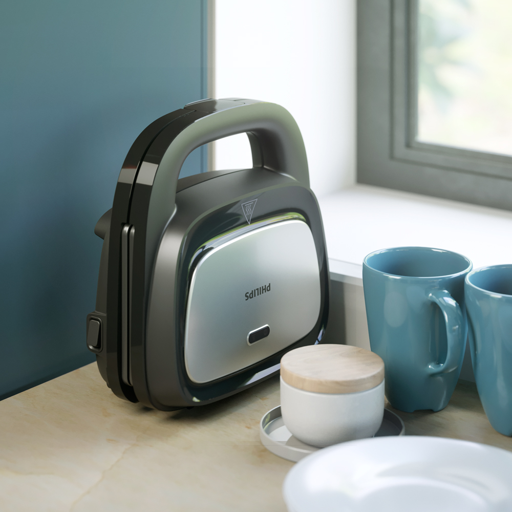 Una sandwichera Philips, negra y plateada, sobre una encimera de madera, cerca de tazas.