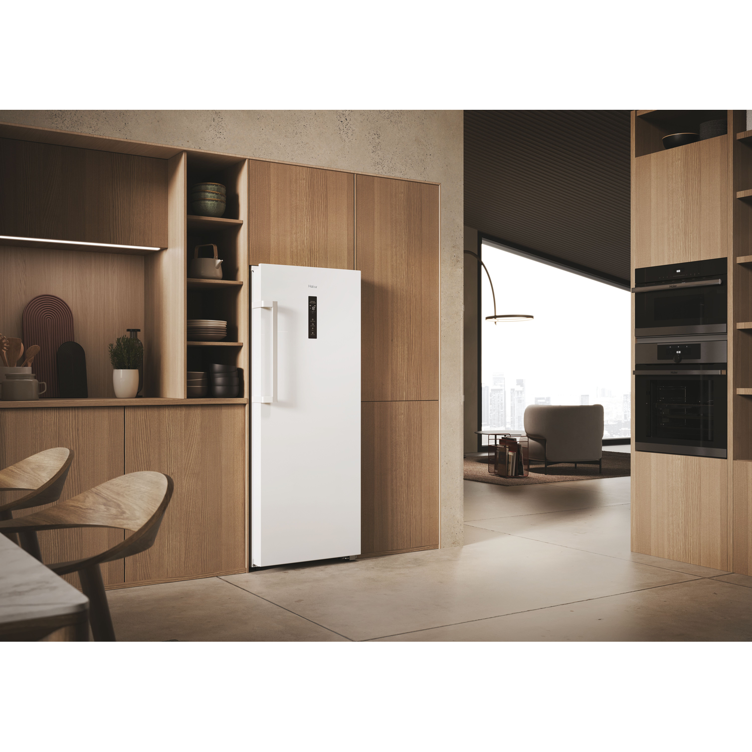 Modern kitchen with a white refrigerator and wooden cabinets and flooring. A view to outside through window.