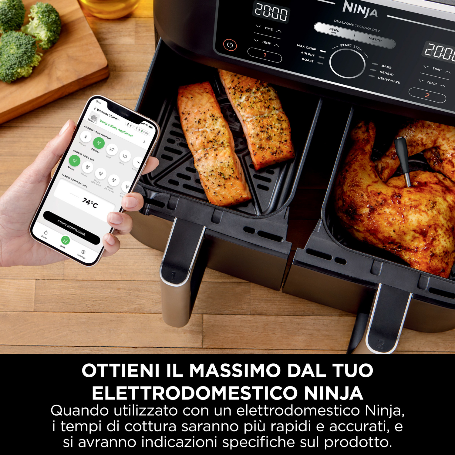 Friggitrice ad aria con salmone e pollo. Un telefono visualizza una ricetta. Il dispositivo ha la tecnologia a doppia zona.