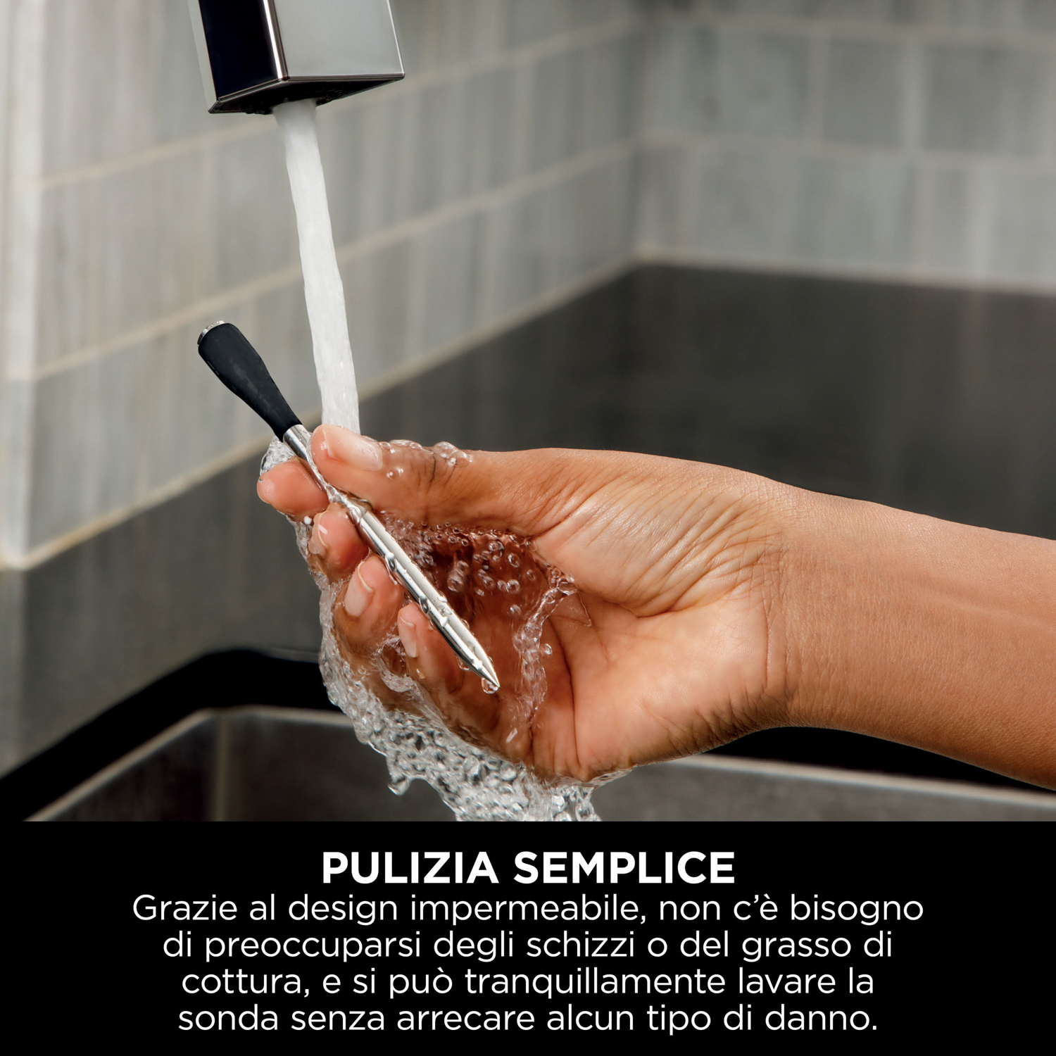 Mano di una persona che lava un utensile da cucina con manico nero sotto l'acqua corrente.