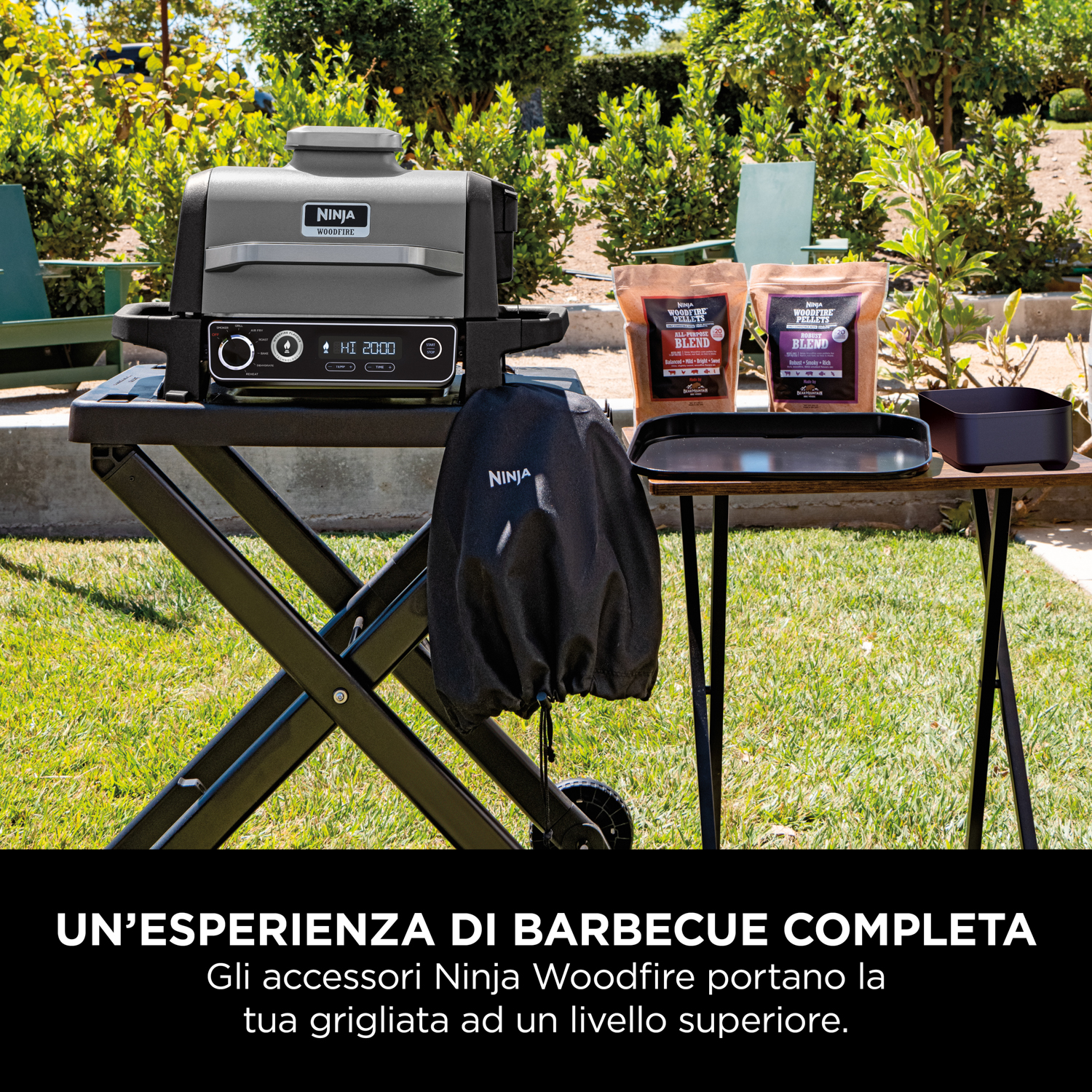 Griglia Ninja da esterno con accessori su un tavolo, in un giardino.