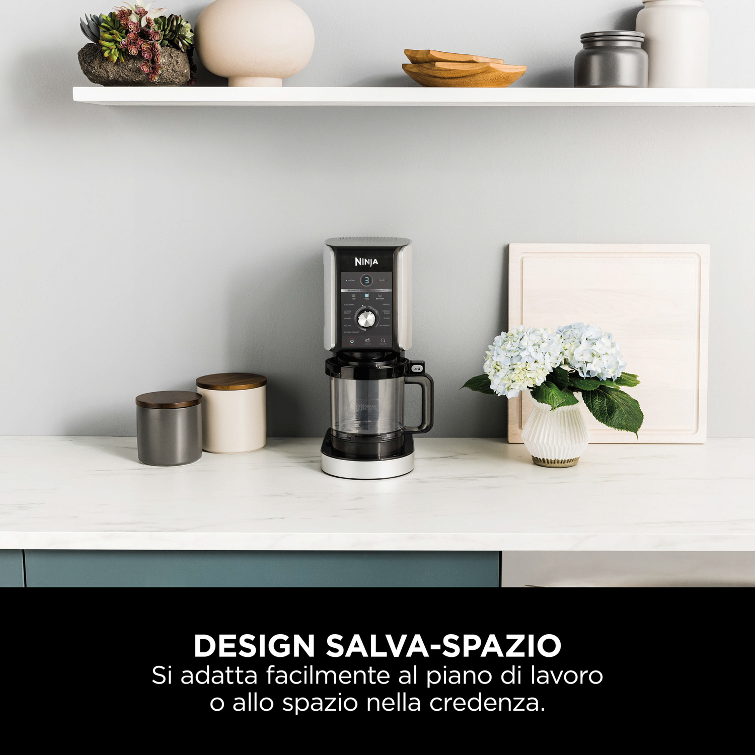 Un frullatore Ninja su un piano cucina, con mensole che contengono piante e decorazioni sullo sfondo.
