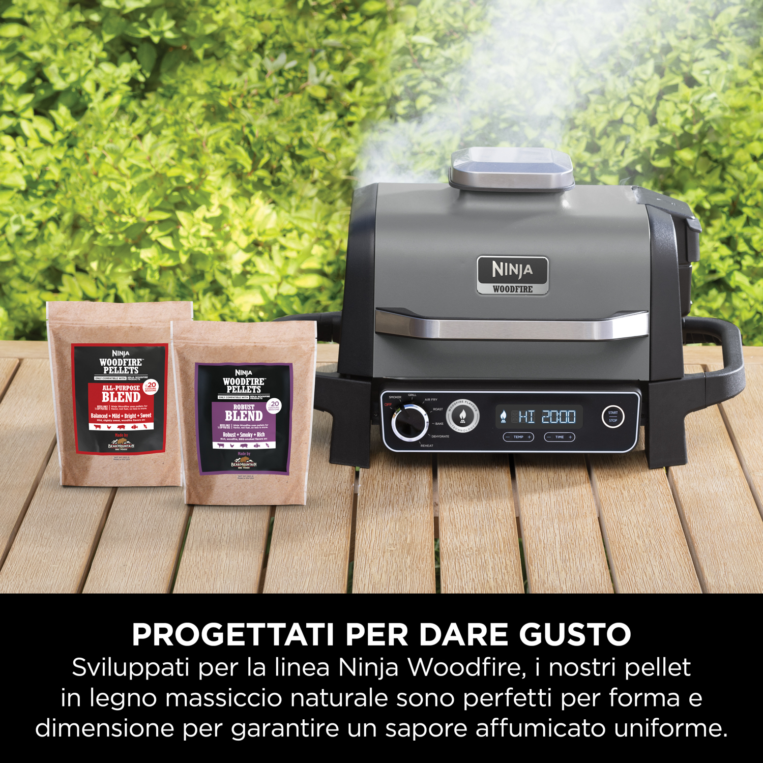Una griglia Ninja Woodfire. La griglia è su un tavolo di legno con due sacchi di pellet.