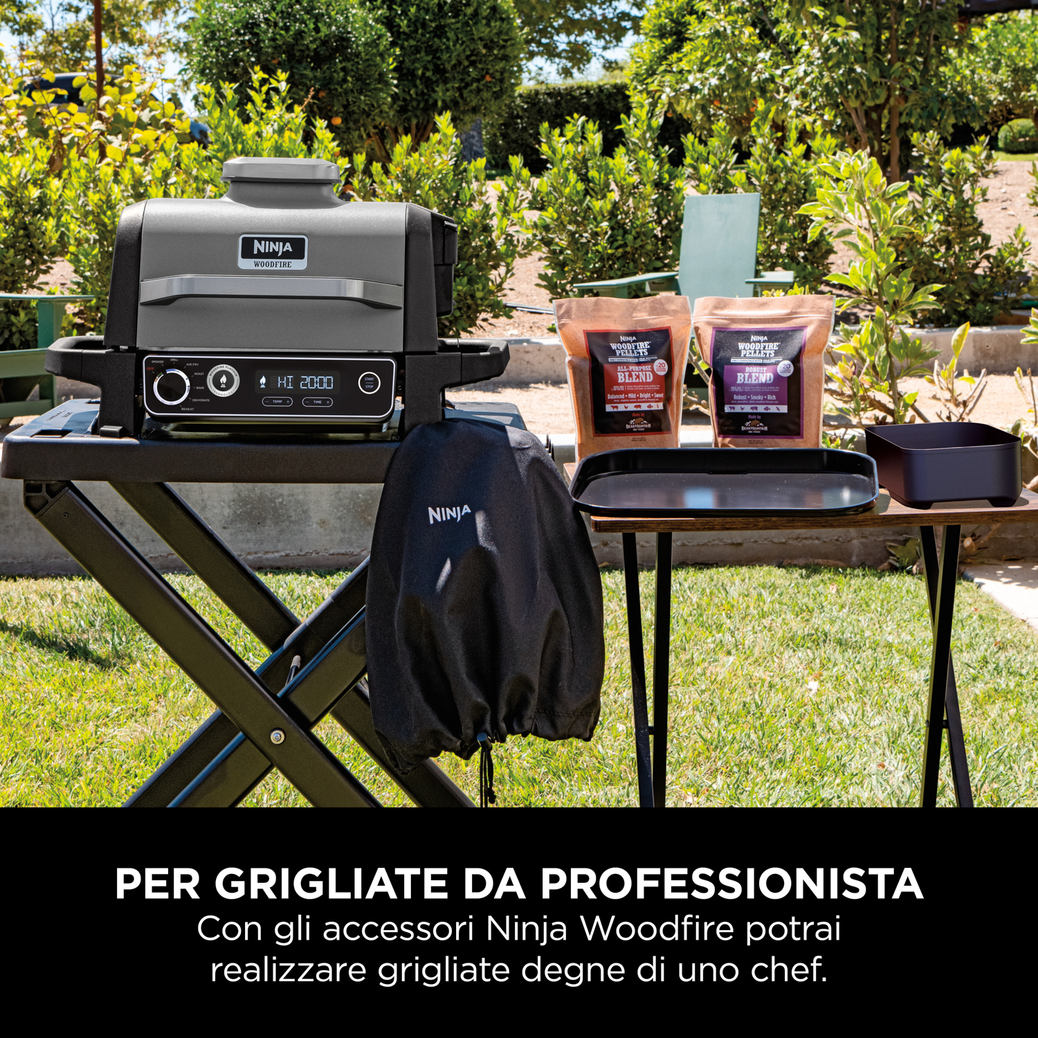 Griglia da esterno su un supporto nero. Due sacchi di trucioli di legno, un vassoio e una copertura.