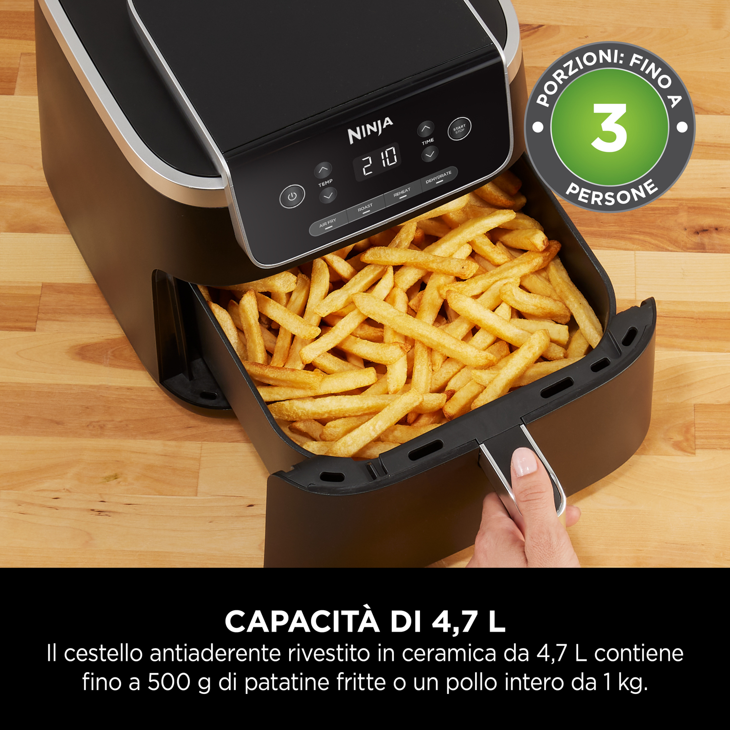 Una friggitrice ad aria Ninja con patatine fritte all'interno. Una persona tiene il cestello delle patatine.