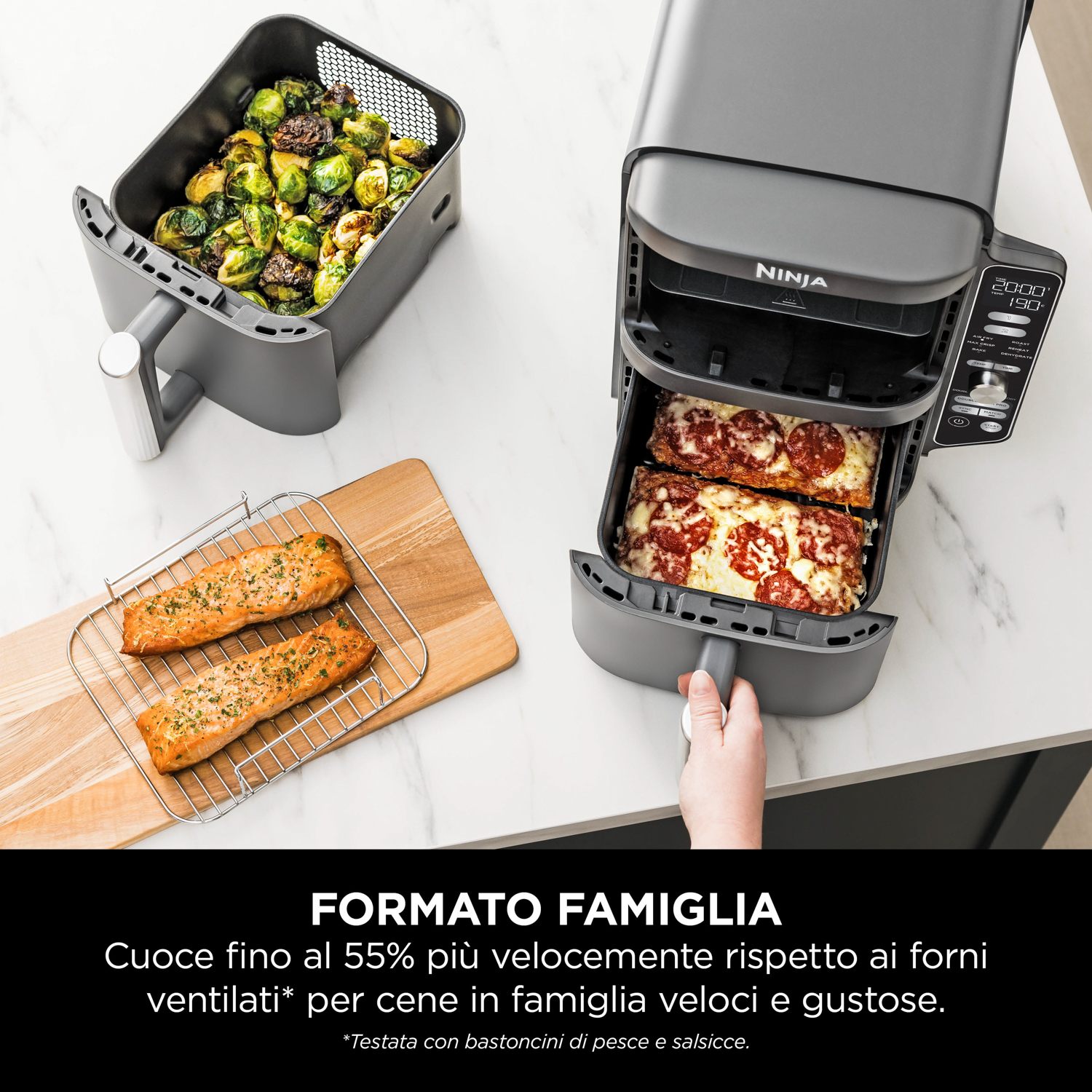 Una friggitrice ad aria Ninja mostra cibo cotto: pizza, salmone e cavoletti di Bruxelles.