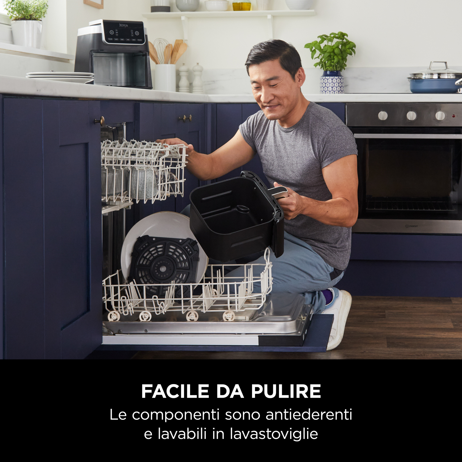 Uomo mette parti della friggitrice nella lavastoviglie. Sfondo cucina con mobili e elettrodomestici.