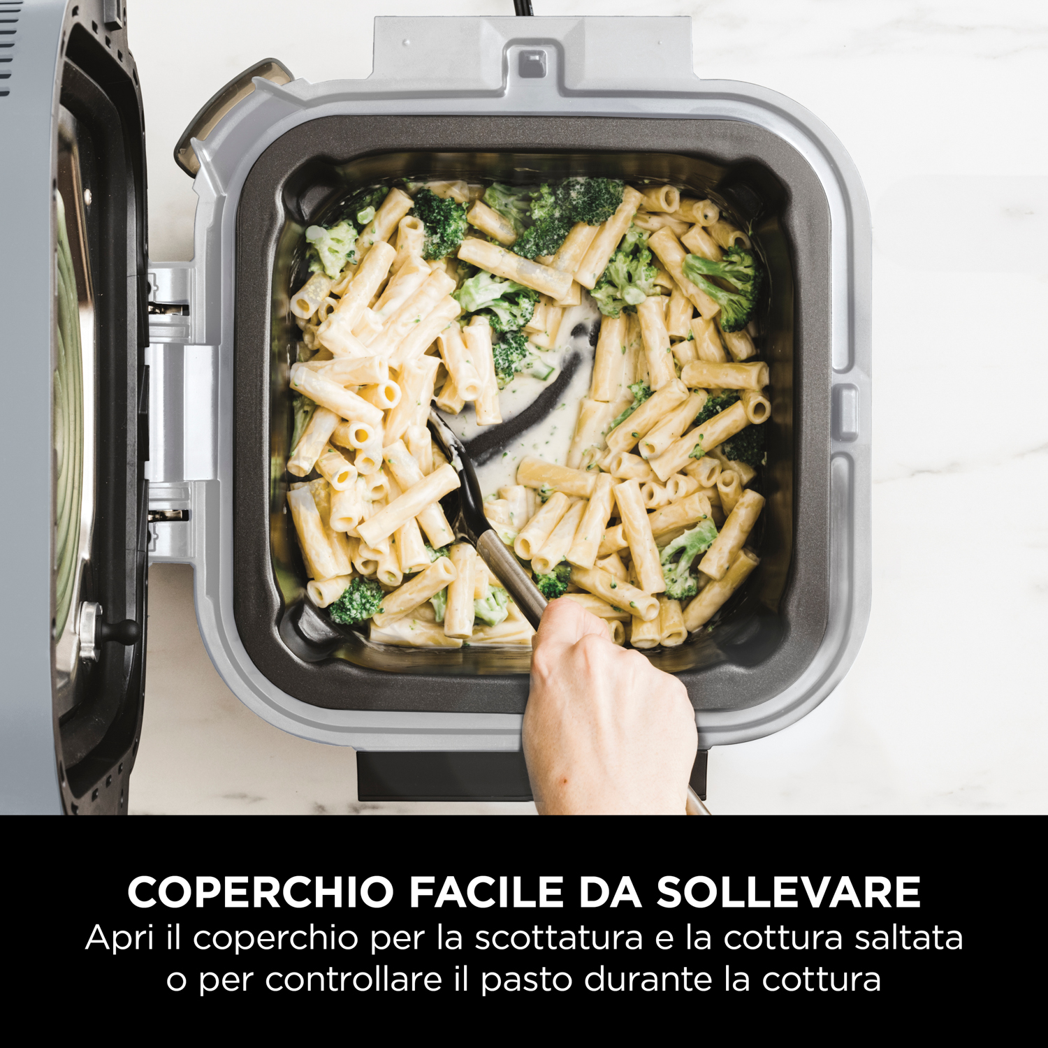 Primo piano di un elettrodomestico da cucina con pasta e broccoli. Una mano tiene un cucchiaio.