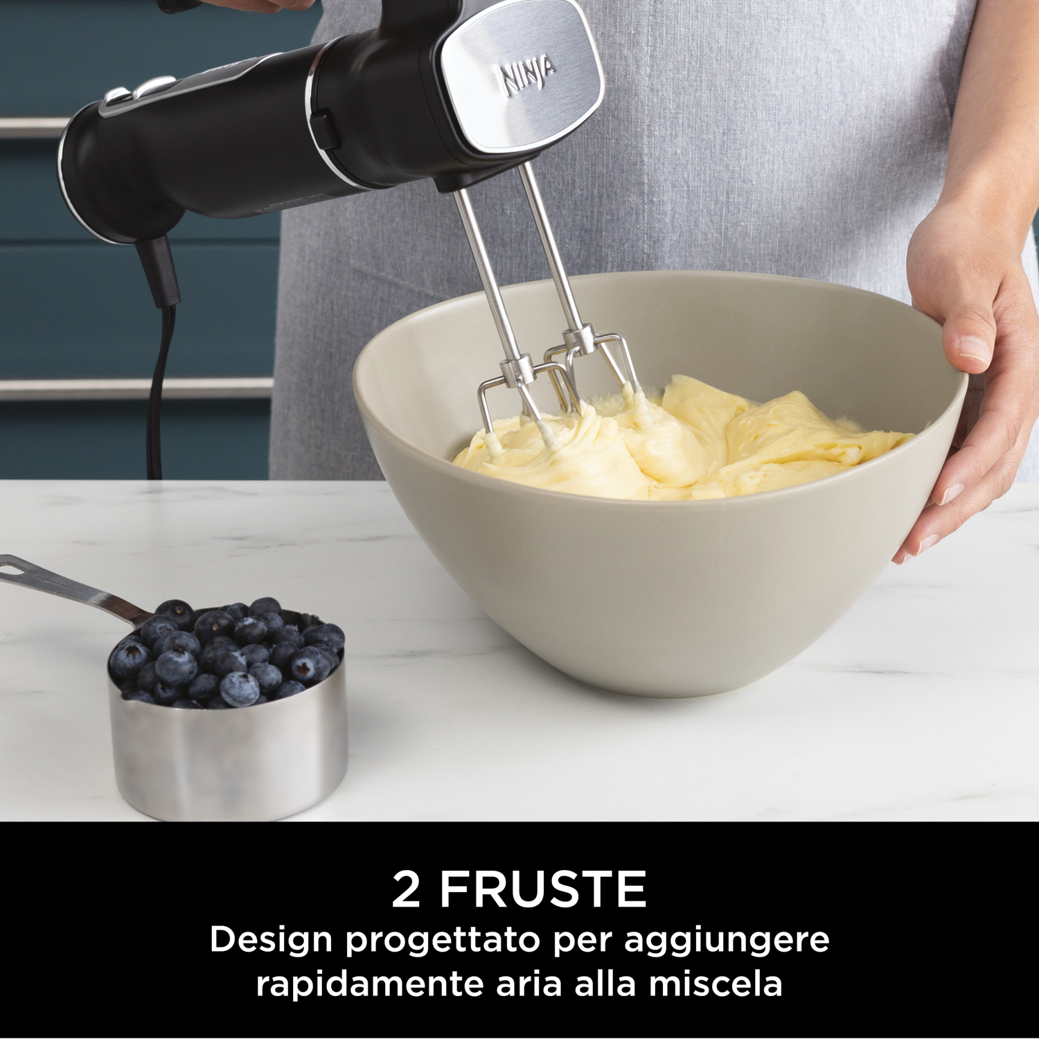 Una persona usa un frullatore a immersione Ninja nero per mescolare gli ingredienti in una ciotola.