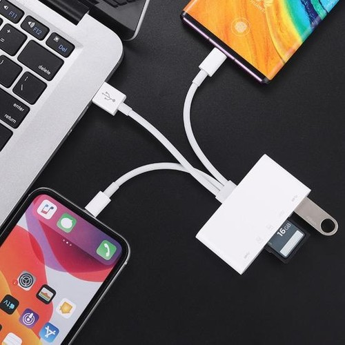 Beyaz bir hub, bir dizüstü bilgisayara, bir telefona ve bir flash sürücü ile başka bir telefona bağlanır.