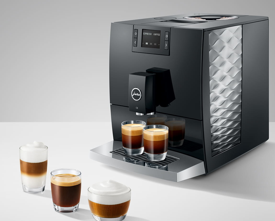 Czarny ekspres do kawy Jura z espresso i napojami mlecznymi. Są trzy porcje kawy i latte.