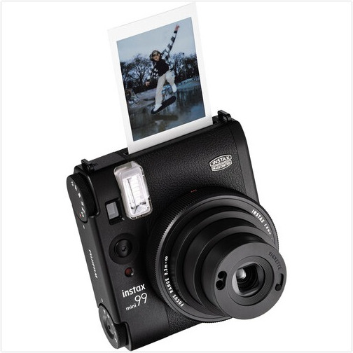 Black Instax 99 camera. A photo is coming out. Camera has lens and flash.