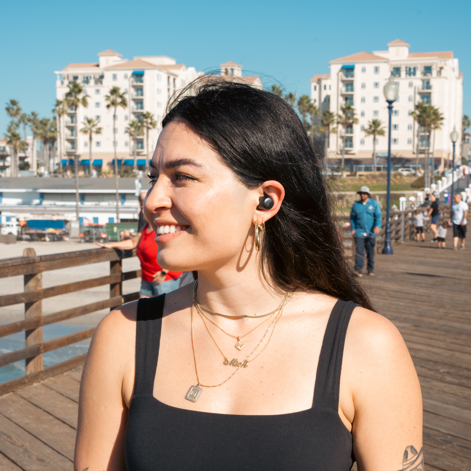 Woman on pier wearing earbuds.