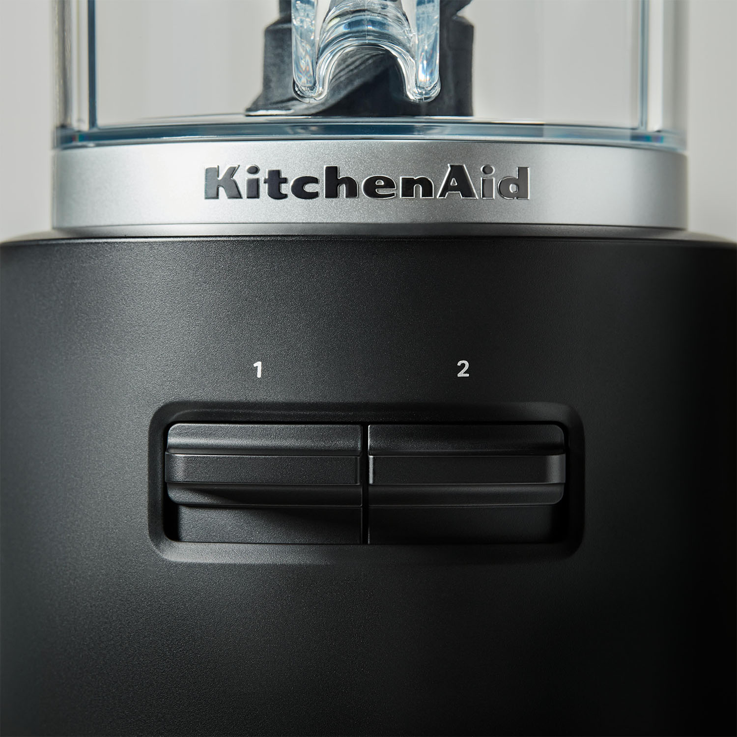 Frullatore KitchenAid nero con due impostazioni di velocità e un contenitore di miscelazione trasparente.