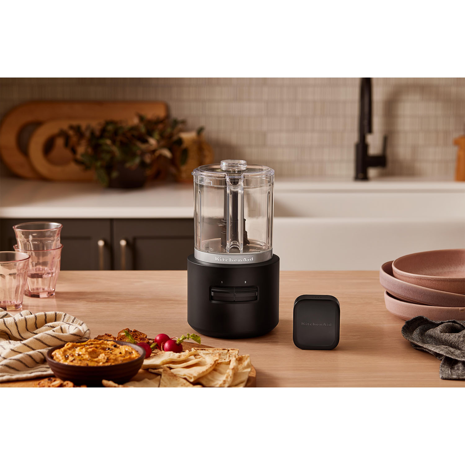 Robot da cucina nero su tavolo di legno con alimenti.