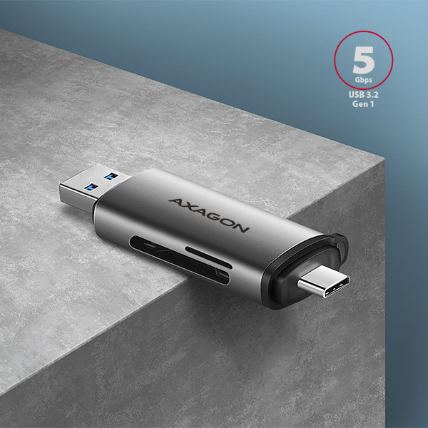Egy ezüst USB kártyaolvasó. A szöveg: 'AXAGON' és '5 Gbps USB 3.2 Gen 1'. Egy szürke felületen van.