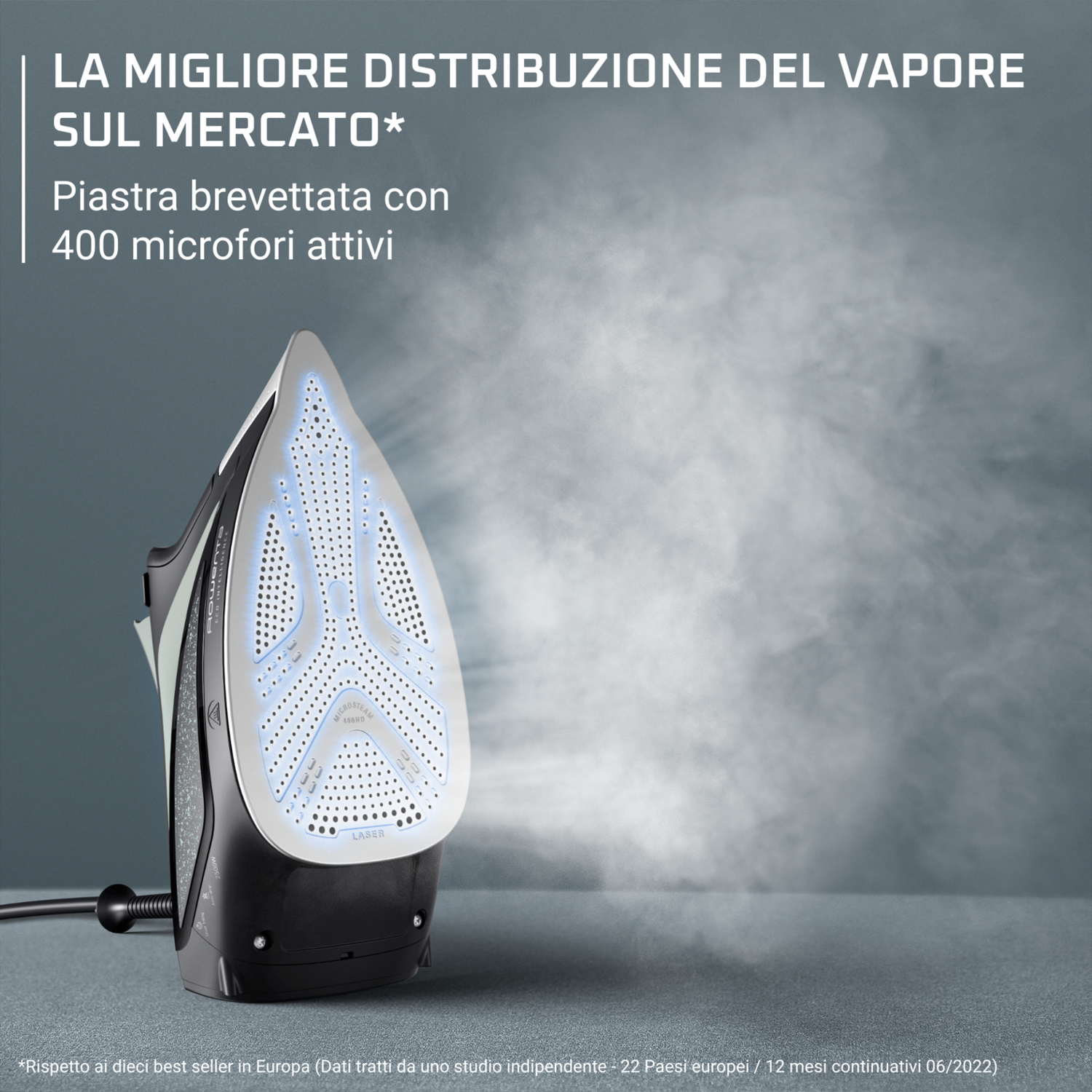 Un ferro da stiro nero e grigio con vapore in uscita, su una superficie grigia.