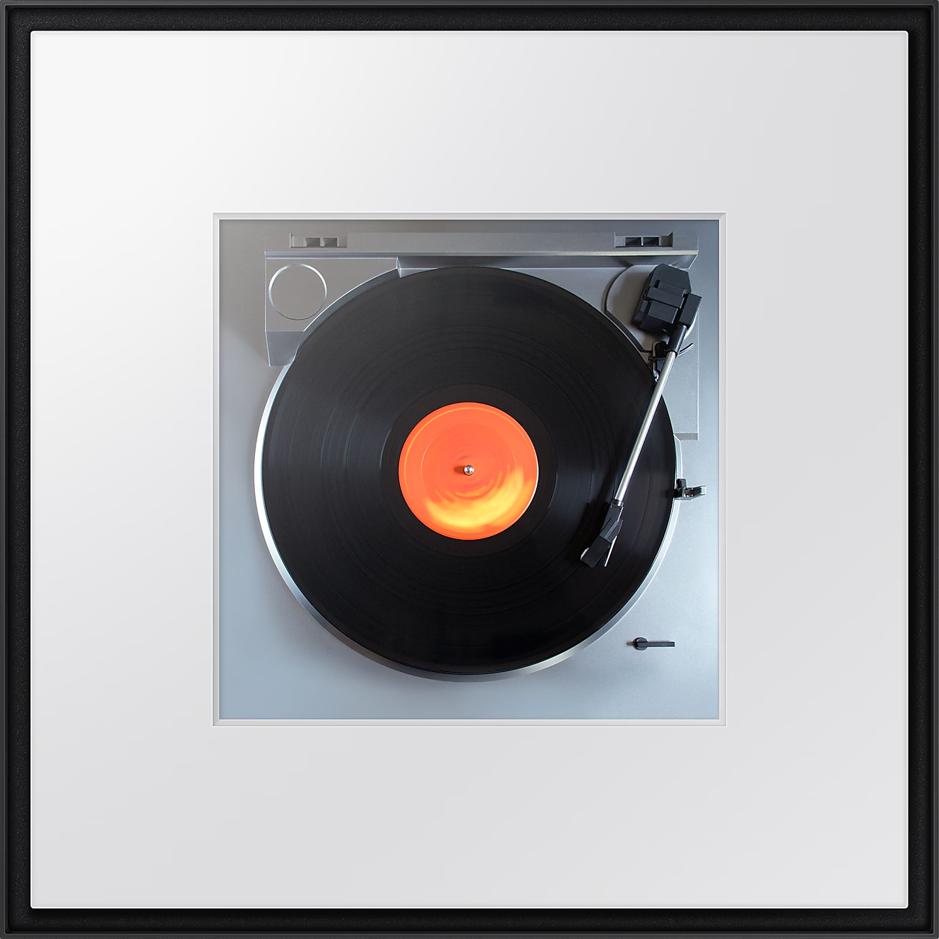 Platine vinyle jouant un disque vinyle. Le disque est noir avec une étiquette centrale orange.