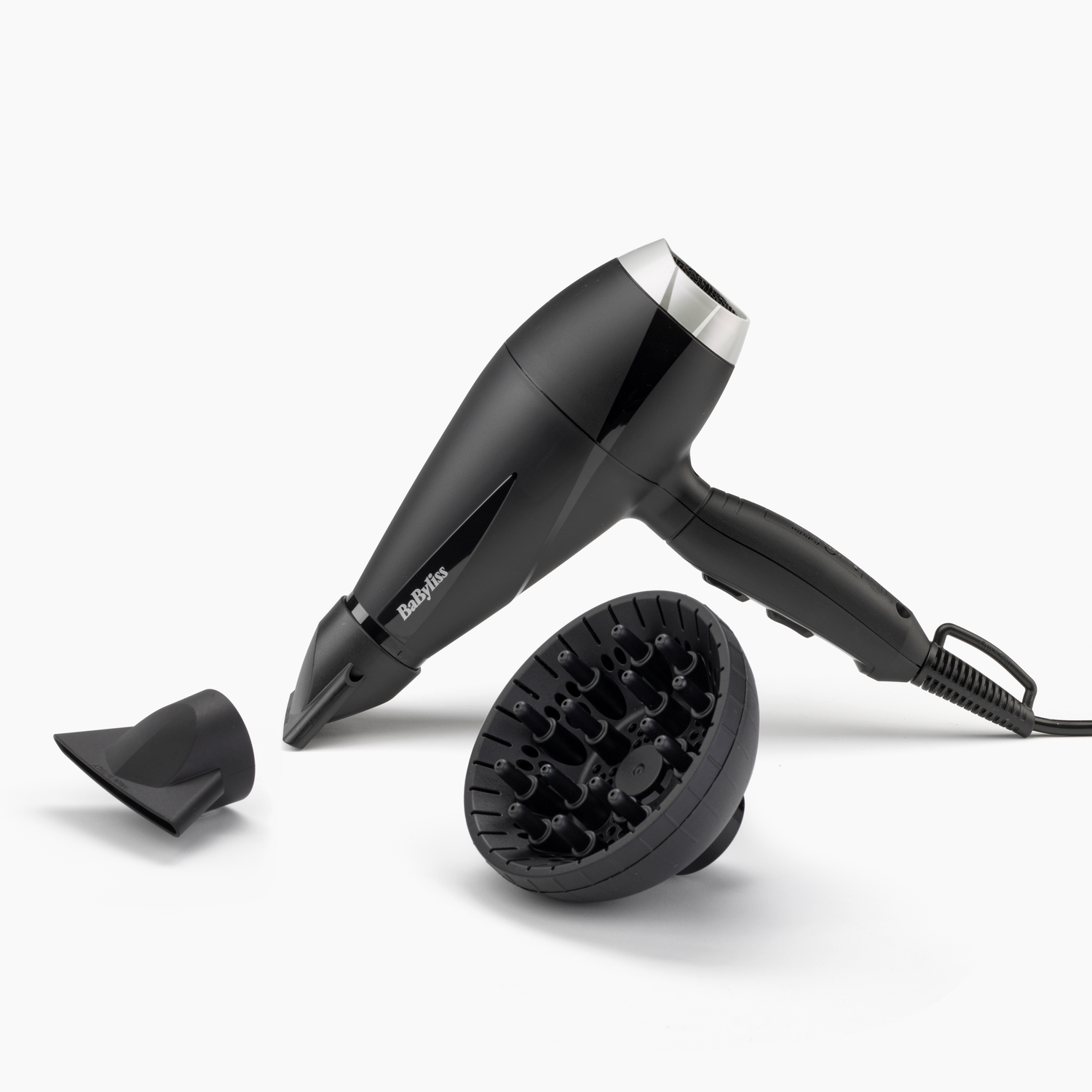 Black hair dryer with nozzle and diffuser. White background. Babyliss brand.