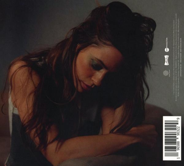 Frau mit langen, dunklen Haaren, blickt nach unten. Dunkler Hintergrund. Albumcover.