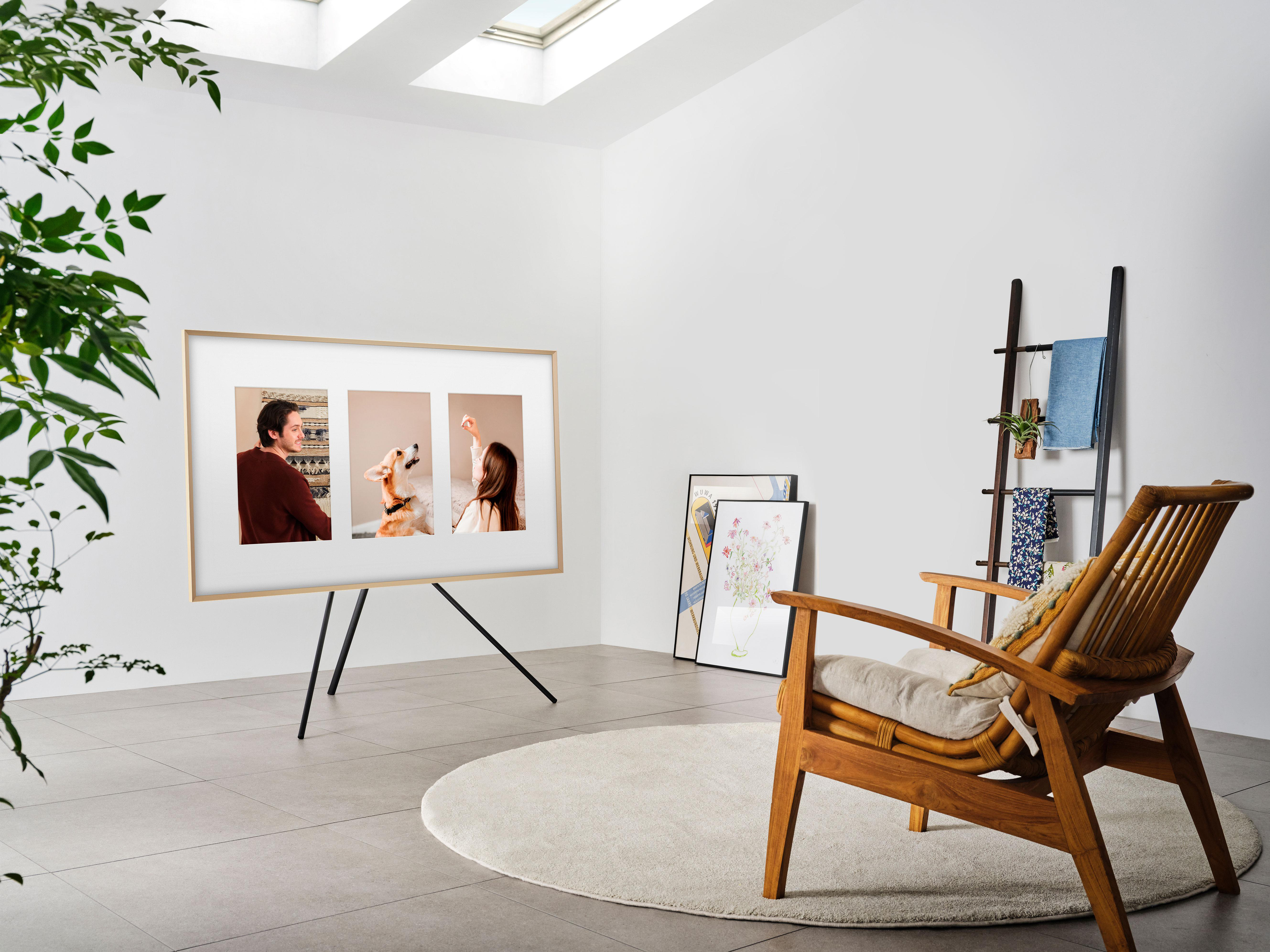 Ein modernes Wohnzimmer mit einem gerahmten Kunst-TV, einem Holzstuhl und einem Teppich.