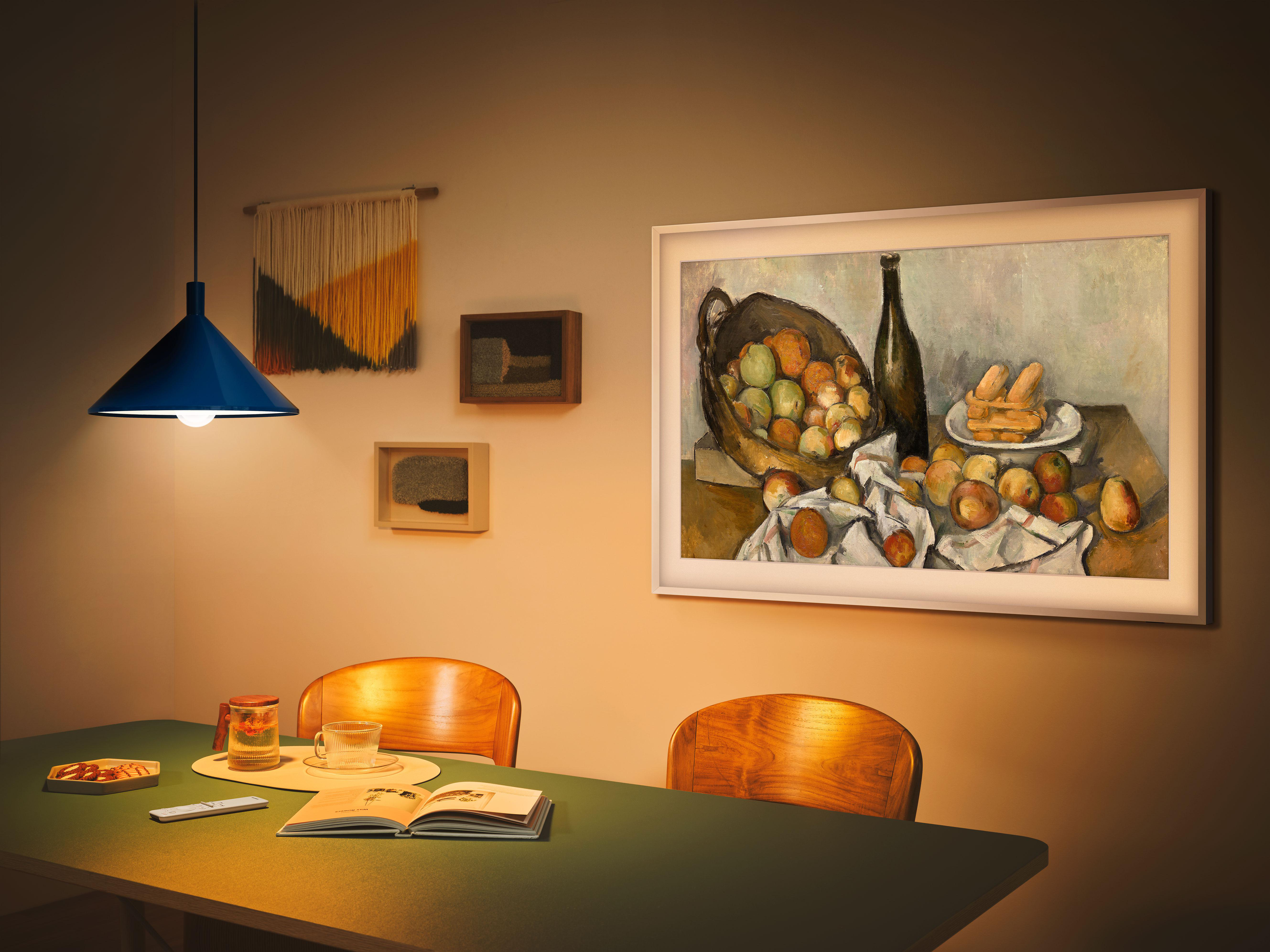 Ein Gemälde von Früchten an der Wand. Ein Tisch mit Objekten im Vordergrund.