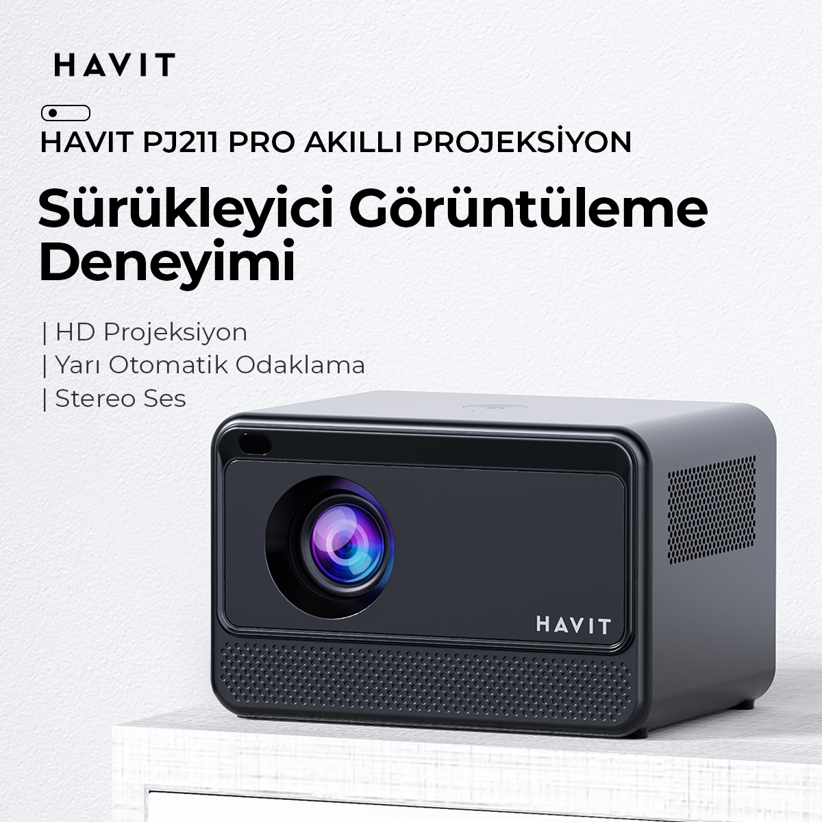 Siyah projektör ve metin. Projektördeki metin 'HAVIT'. Beyaz bir yüzeyde.
