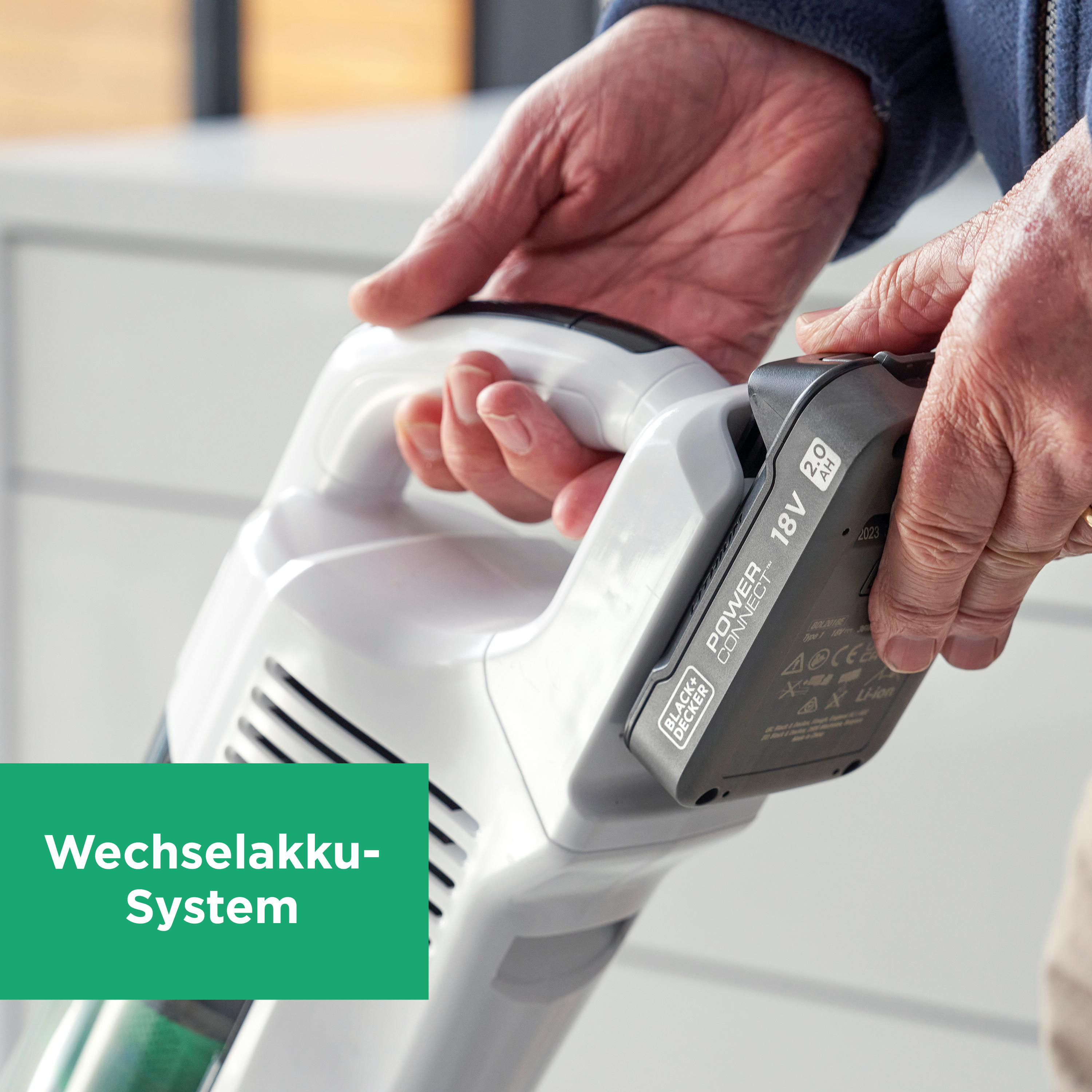 Person hält Akku-Staubsauger, befestigt Akku. Text: Wechselakku-System.