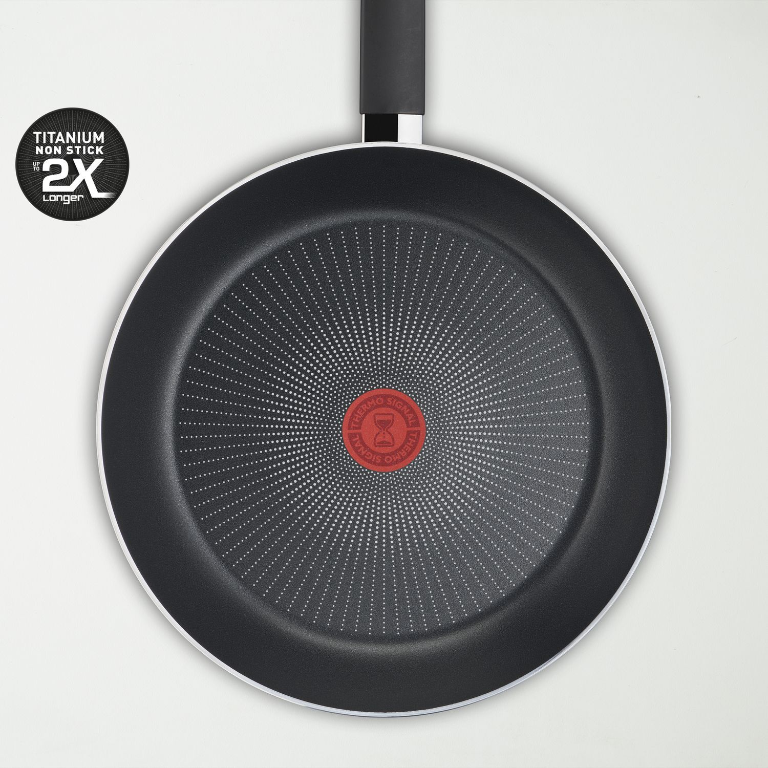 Black frying pan. Red circle in the center. White dots radiate out from center.