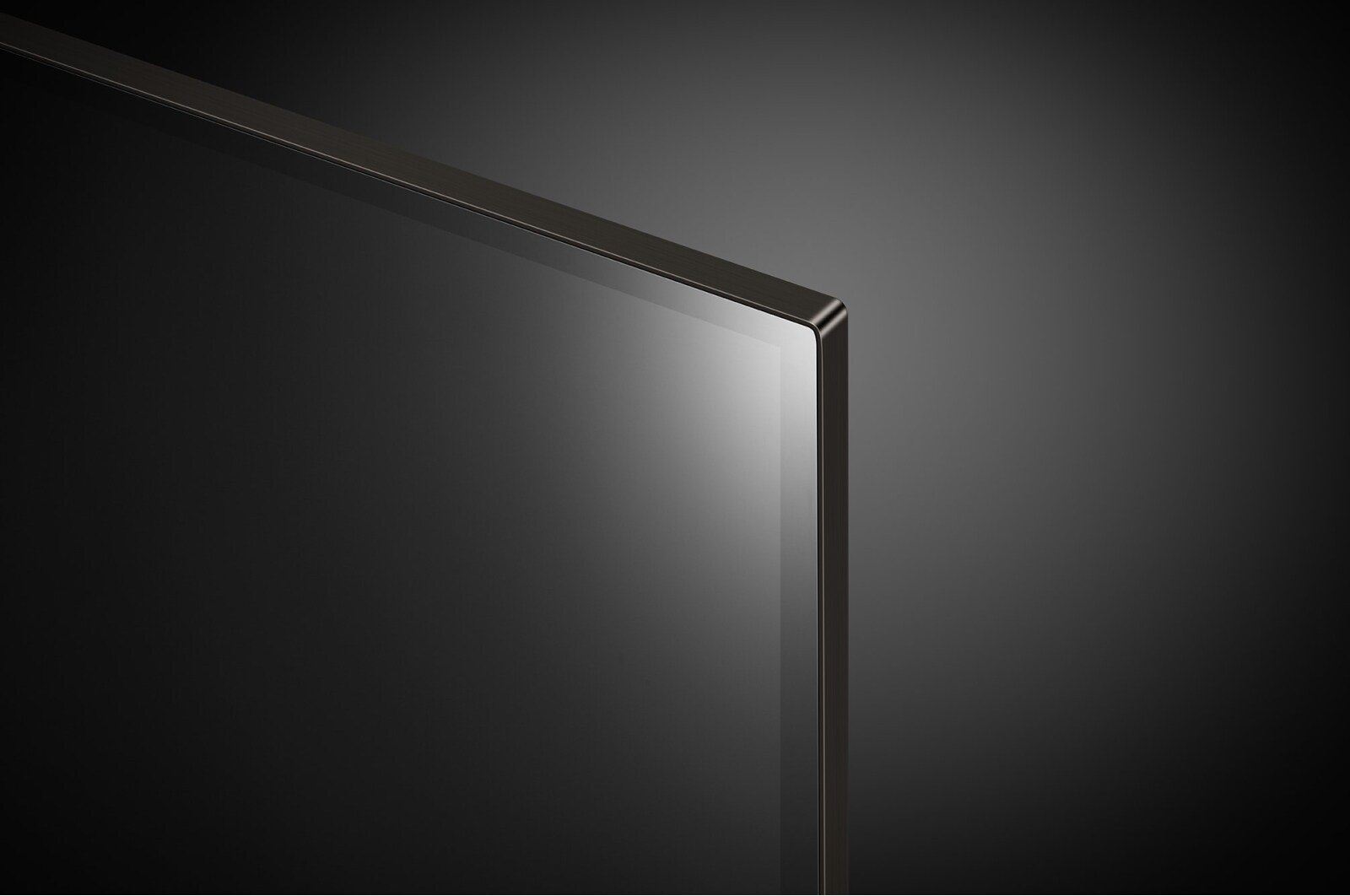 Primo piano di un angolo TV. Lo schermo è nero ed elegante con una cornice metallica sottile.